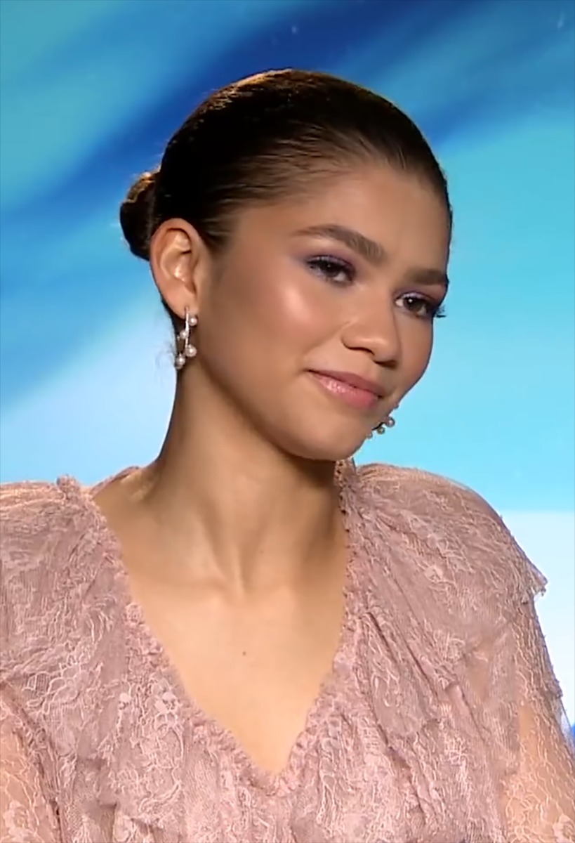 Foto de Zendaya en una alfombra roja, sonriendo a la cámara